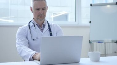 Dalgın doktor düşünme ve çalışma üstünde laptop
