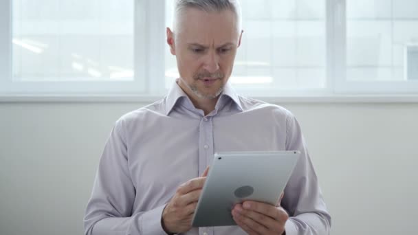Середній у віці чоловік засмучений втрати при використанні Tablet — стокове відео