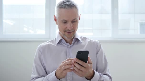 Moyen Age Homme excité pour le succès tout en utilisant Smartphone — Video
