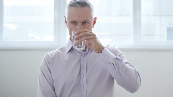 Бизнесмен пьет воду в офисе — стоковое видео