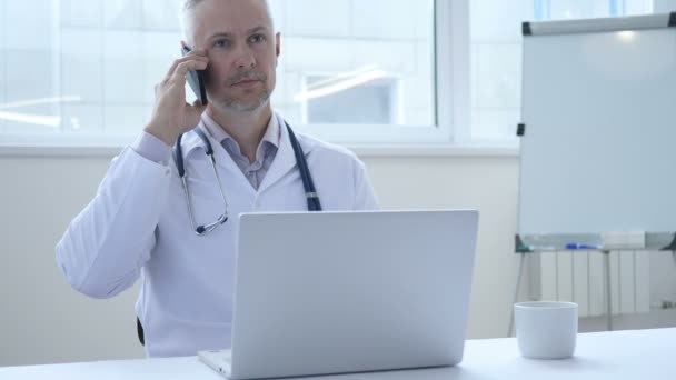 Доктор розмовляє по телефону з пацієнтом — стокове відео