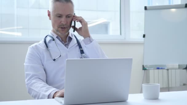 Rozmowy telefon przez lekarza w pracy — Wideo stockowe