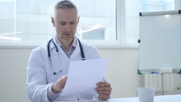 Arzt liest medizinische Papiere in Klinik — Stockvideo