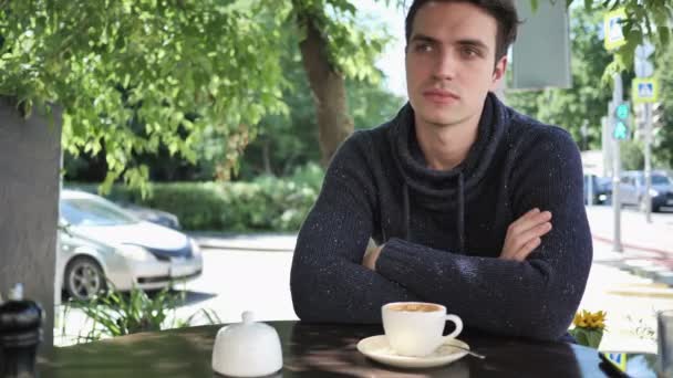 Νεαρός άνδρας κάθεται στην βεράντα του Cafe — Αρχείο Βίντεο