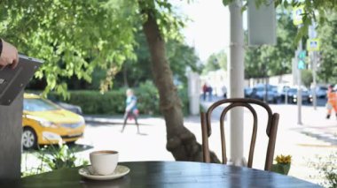 Adam geliyor ve Cafe Teras oturma ve açılış üstünde Laptop