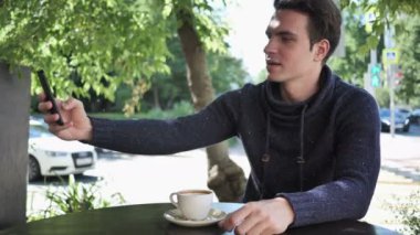 Genç adam alarak Selfie Cafe Teras otururken telefon