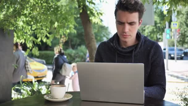 Человек закрывая ноутбук и выходя из кафе терраса — стоковое видео