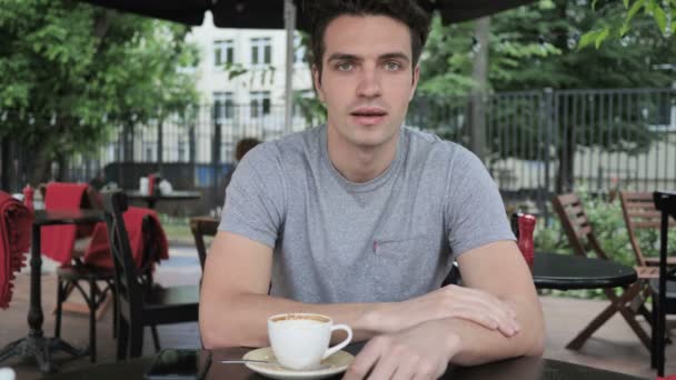 카페 테라스에 앉아 웃는 젊은 남자 — 비디오