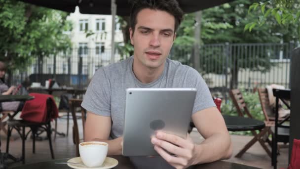 Chat vidéo en ligne sur tablette par l'homme assis dans Cafe Terrace — Video