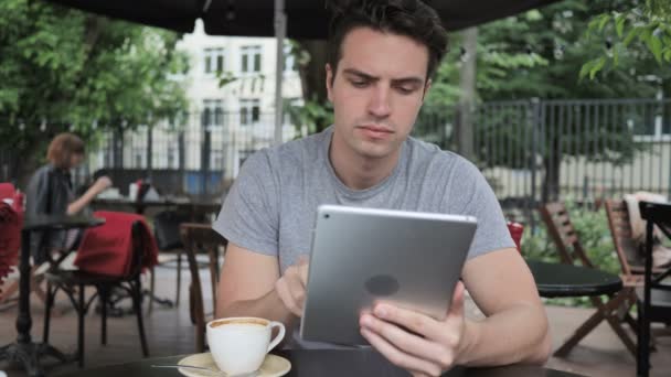 Człowiek z picia kawy i przeglądanie na tablecie siedząc w Cafe Terrace — Wideo stockowe