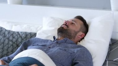 Rahatsız adam yatakta, huzursuzluk uyumaya çalışıyor