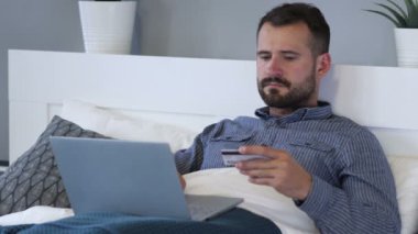 Laptop adam yatakta, ödeme tarafından online alışveriş