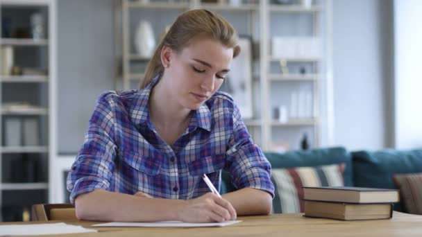 Papeleo, Mujer joven escribiendo mientras está sentada en el escritorio — Vídeo de stock