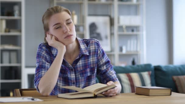Mujer joven pensativa leyendo libro y pensando — Vídeo de stock