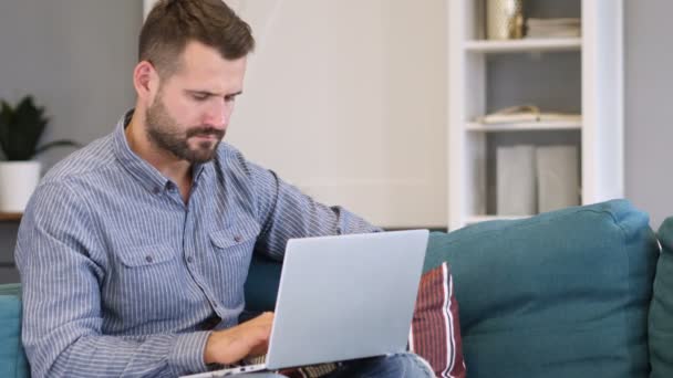 Homem Pensivo Trabalhando no Laptop no Quarto — Vídeo de Stock
