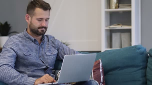 Unavený muž spí na gauči při práci na notebooku — Stock video