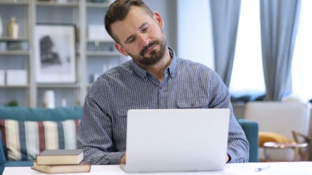 Hombre cansado con dolor de cuello trabajando en el ordenador portátil — Vídeo de stock