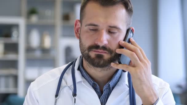 Врач обсуждает с пациентом во время телефонной беседы — стоковое видео