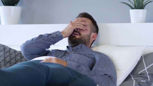 Плачущий грустный человек, лежащий в постели — стоковое видео
