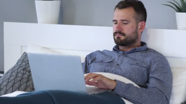 Man Working on Laptop while Relaxing in Bed — Stock Video