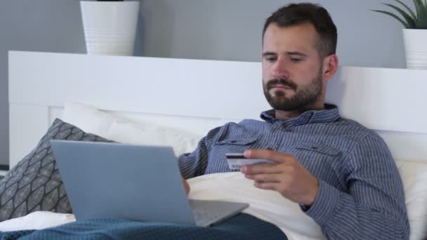 Online-Shopping am Laptop von Mann im Bett, Bezahlung — Stockvideo