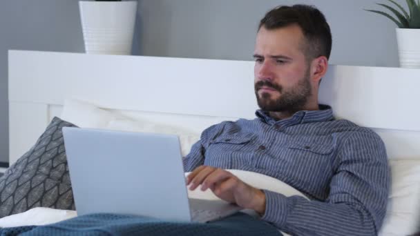 Reacción de la pérdida por el hombre triste usando el ordenador portátil en la cama — Vídeos de Stock