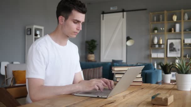 Hombre joven trabajando en el ordenador portátil — Vídeos de Stock