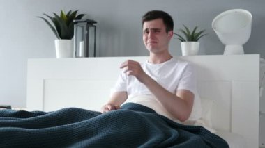 Yatakta ağlayan üzgün genç adam