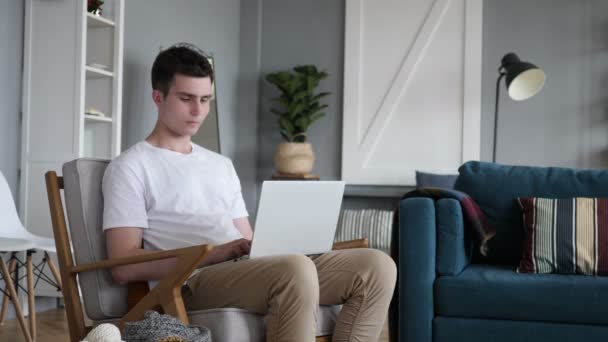 Чоловік залишає диван після роботи на ноутбуці — стокове відео