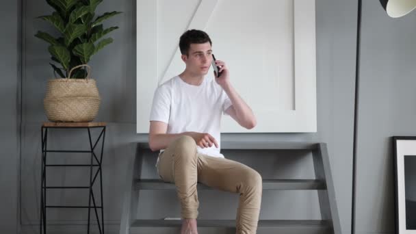 Merdivenlerde otururken adam Talking telefon — Stok video