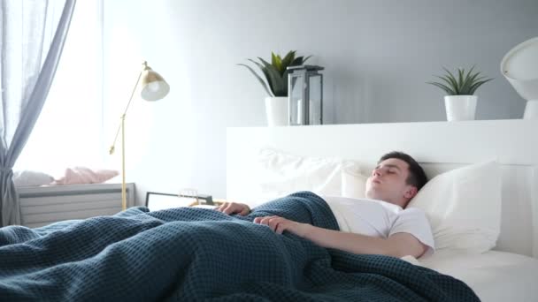 Frischer Mann wacht aus Schlaf im Bett auf — Stockvideo