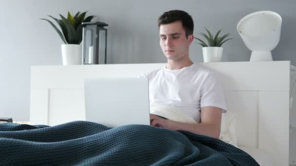 Reakcja sukcesu przez szczęśliwy człowiek korzysta z laptopa w łóżku — Wideo stockowe