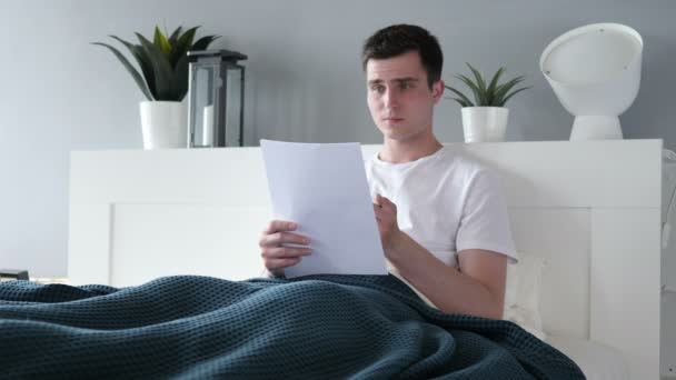 Homme en colère bouleversé après avoir lu des documents au lit — Video