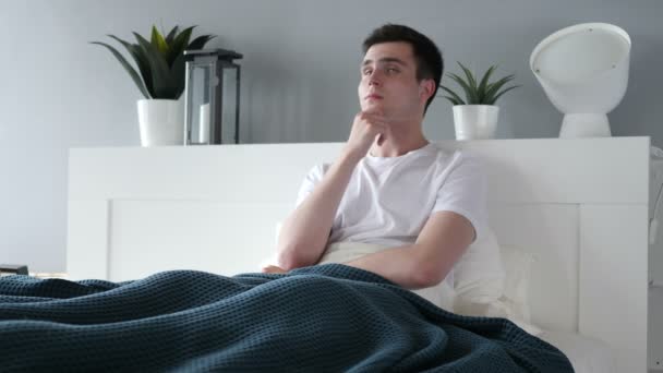 Pensamiento del hombre pensativo mientras está sentado en la cama — Vídeo de stock