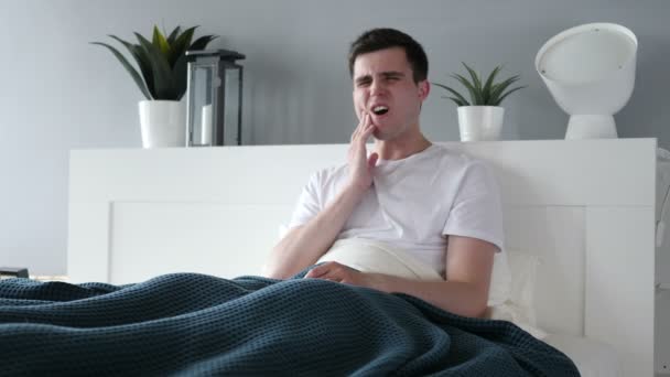 Πονόδοντο, άνθρωπος με πόνο στο δόντι κάθεται στο κρεβάτι — Αρχείο Βίντεο