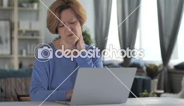 Yorgun eski üst düzey kadın boyun ağrısı dizüstü bilgisayarda çalışma ile