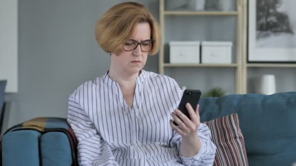 Vieille femme âgée bouleversé pour la perte tout en utilisant Smartphone — Video