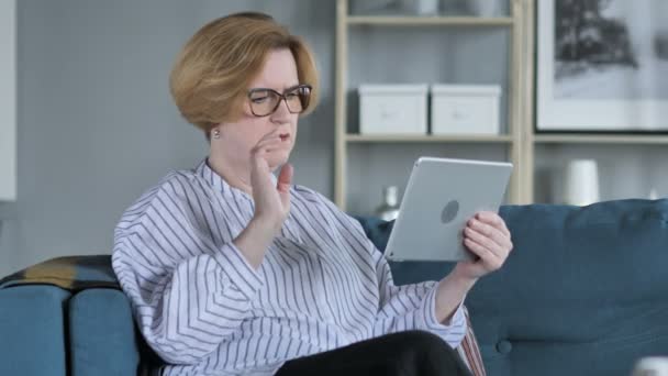 Senior vrouw reageren op financieel verlies terwijl met behulp van Tablet PC — Stockvideo