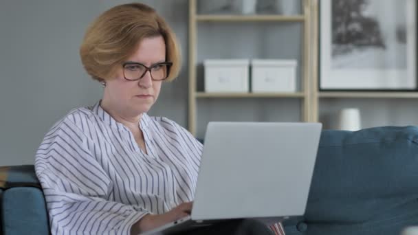 沉思的老资深妇女在笔记本电脑上思考和工作 — 图库视频影像