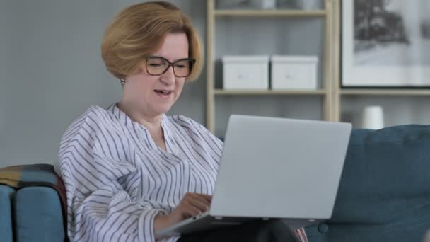 Kadın kıdemli Online Video sohbet etmek üstünde Laptop iş başında — Stok video