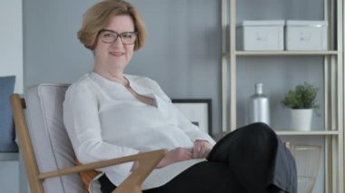 Kameraya bakarak eski kadın kıdemli oturan gülümseyen
