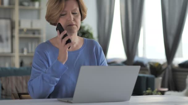 Oude Senior vrouw praten over telefoon op werk — Stockvideo