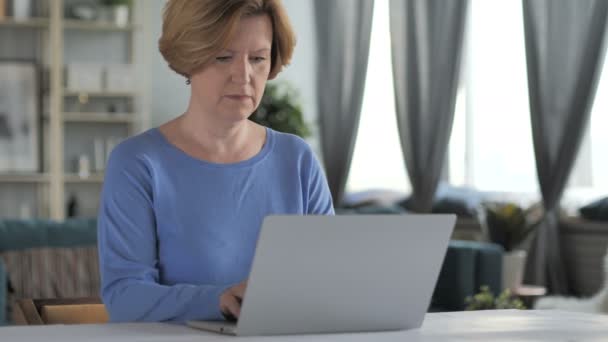 Уход пожилой женщины после завершения работы над ноутбуком — стоковое видео