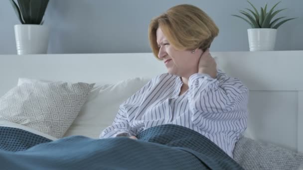 Cansada velha mulher sênior com dor no pescoço na cama — Vídeo de Stock