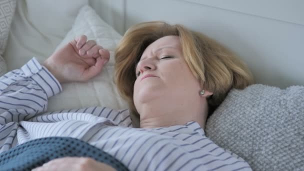 Upprörd gamla Senior Kvinna med huvudvärk som sover i sängen — Stockvideo