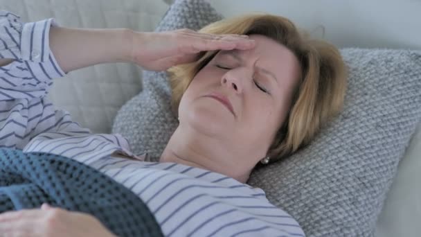 Stara kobieta Senior z bólem głowy, spanie w łóżku — Wideo stockowe