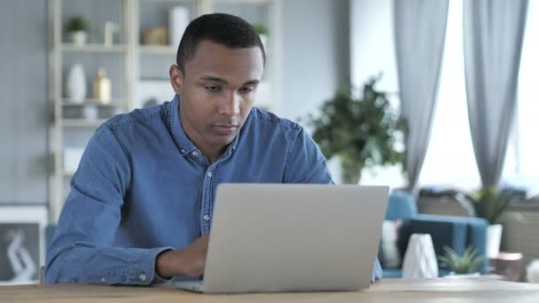 Scioccato, stordito giovane africano uomo chiedendo e lavorando sul computer portatile — Video Stock