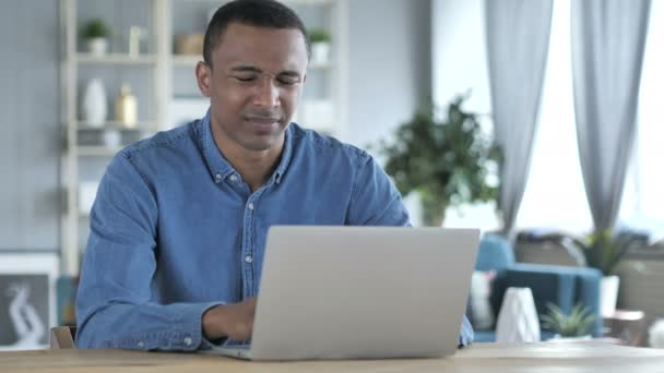 Moe van Afrikaanse jongeman met nekpijn die op Laptop werkt — Stockvideo