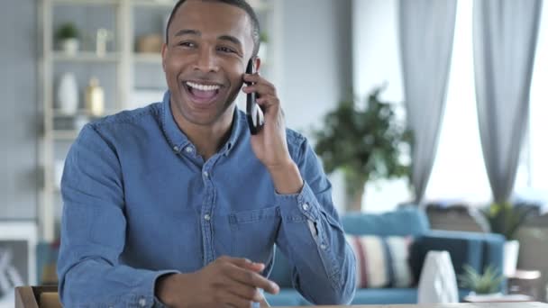 Jovem Africano discutindo o trabalho no telefone — Vídeo de Stock