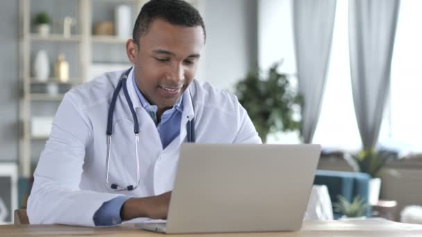 Афроамериканский врач работает над ноутбуком — стоковое видео